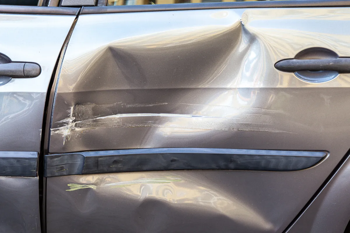 a close up of a car door with a denting dent
