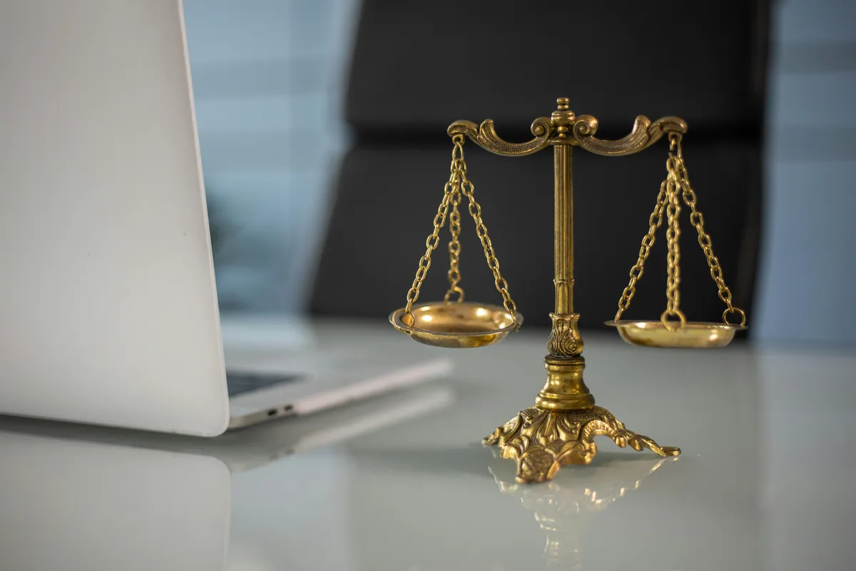 a gold scale on a desk with a laptop