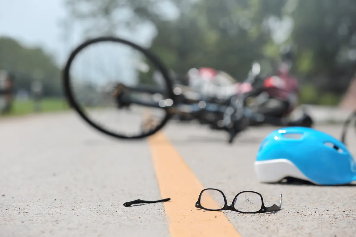 a helmet and glasses on the ground next to a bike