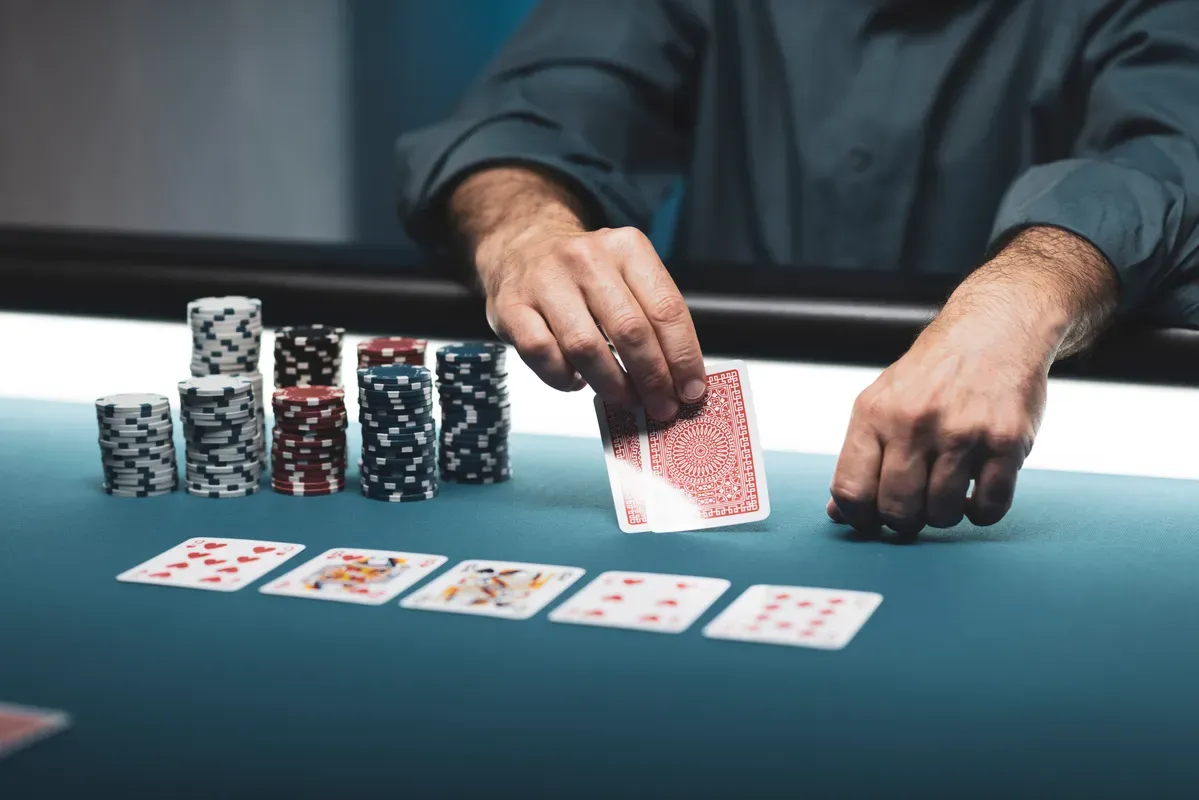 a man is playing cards on a table with stacks of chips