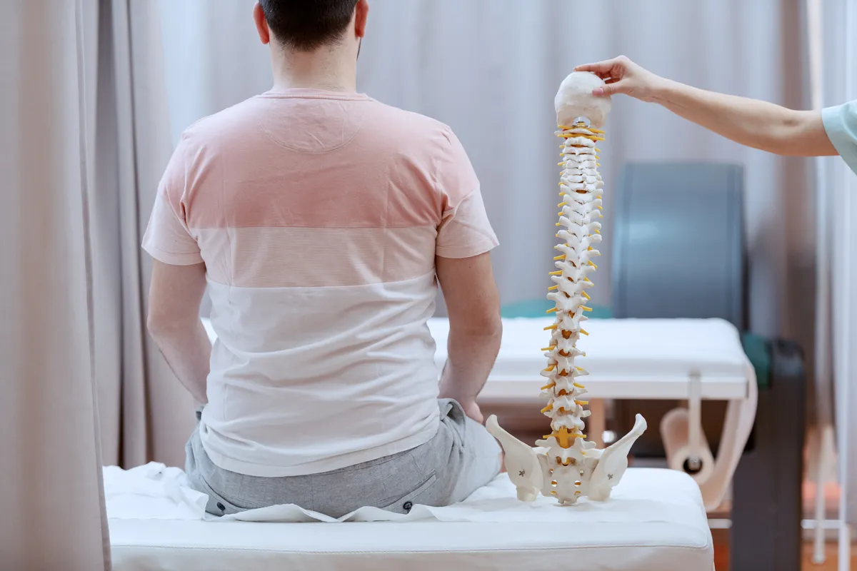 a man sitting on a bed with a chiroptictor