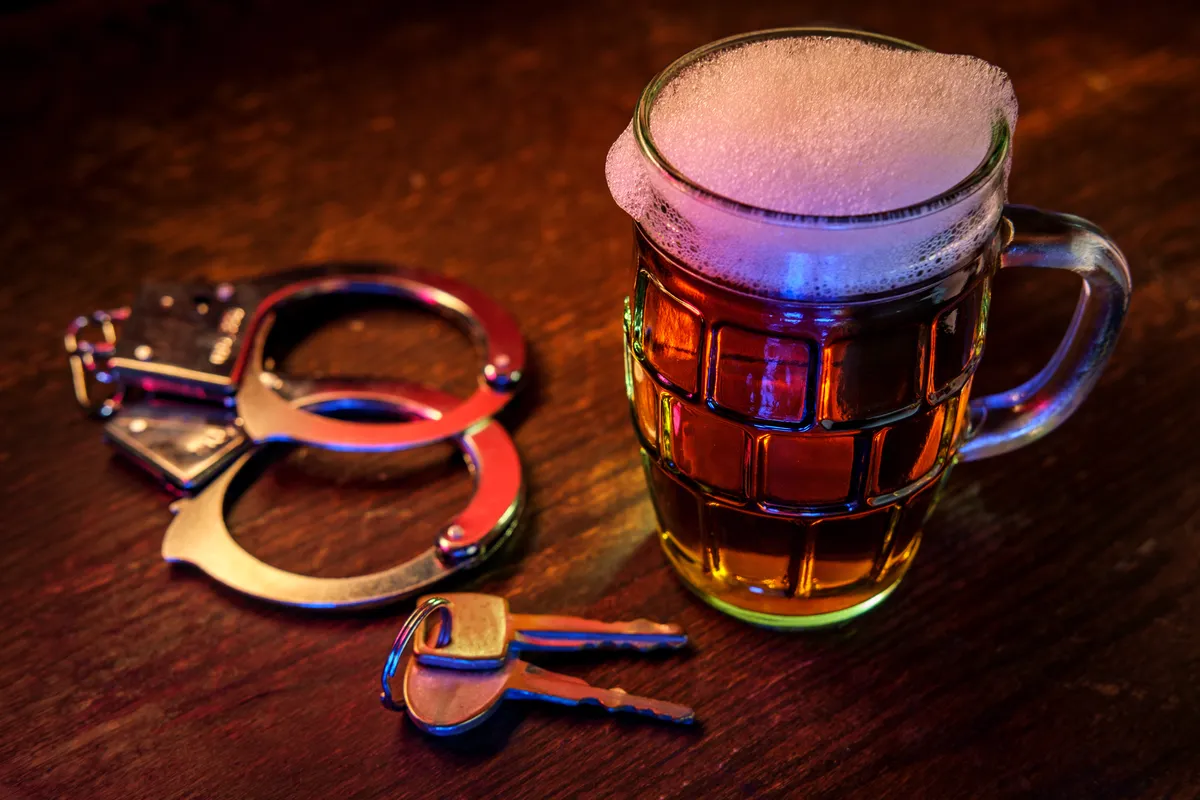 a mug of beer and handcuffs on a table