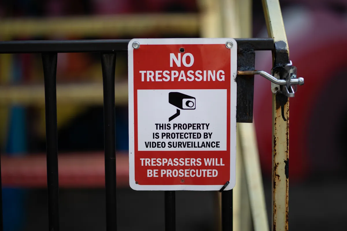 a sign that says no trespassing on the gate