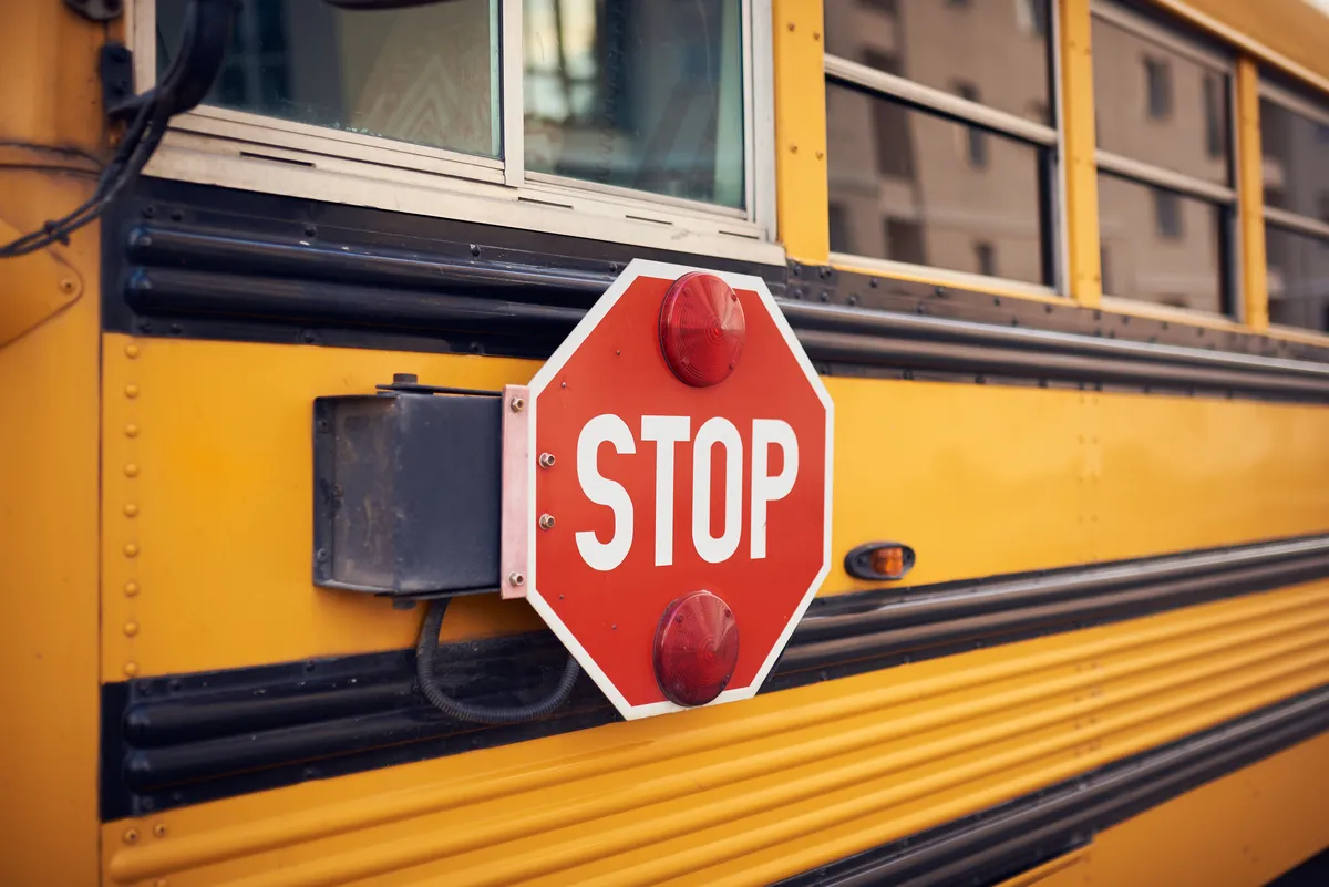 arafed stop sign on a school bus with a window in the background