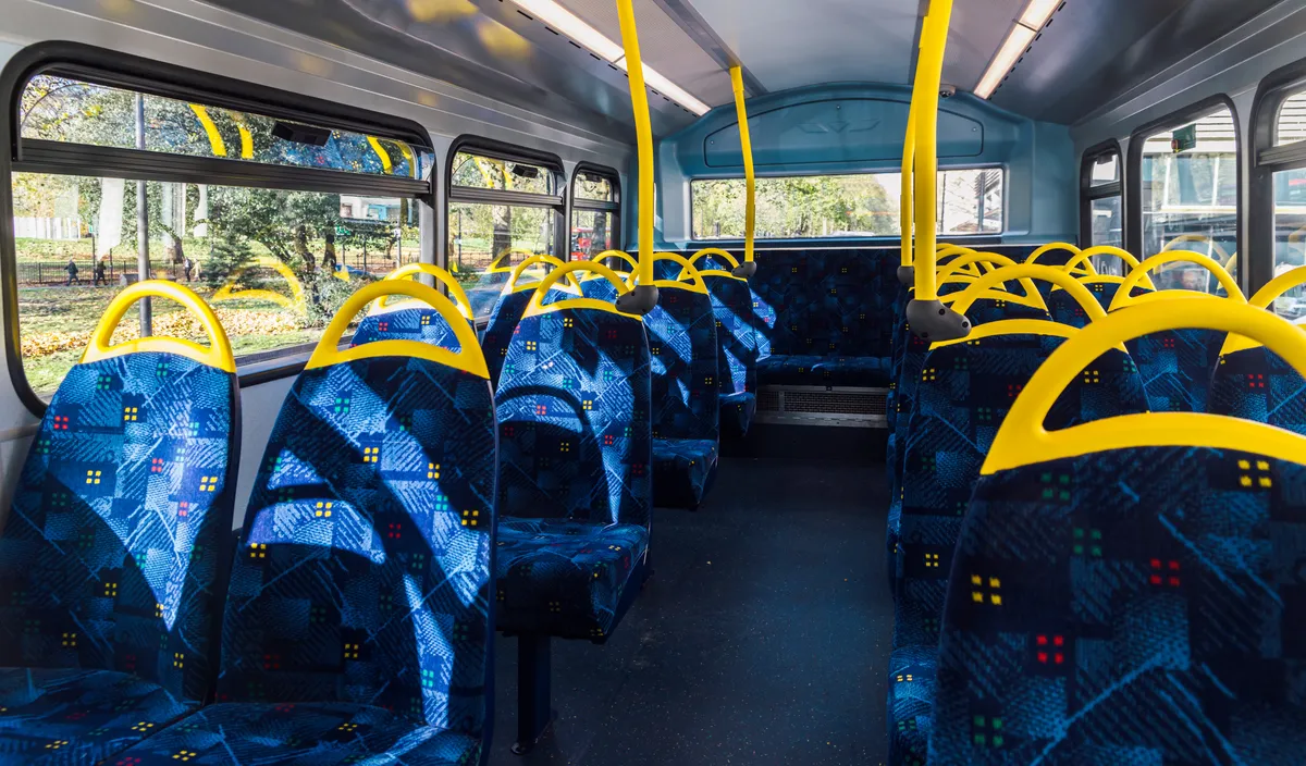 arafed view of a bus with blue seats and yellow handles
