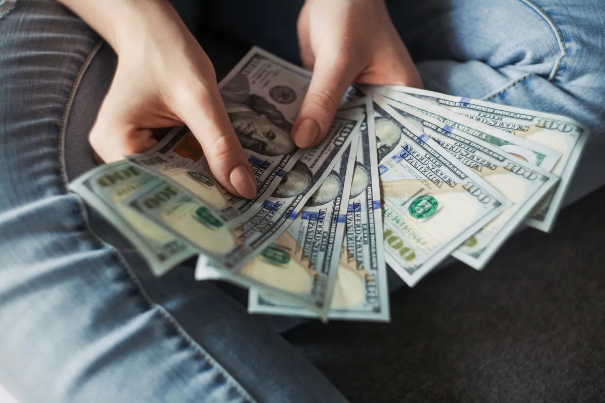 someone holding a stack of money in their hands