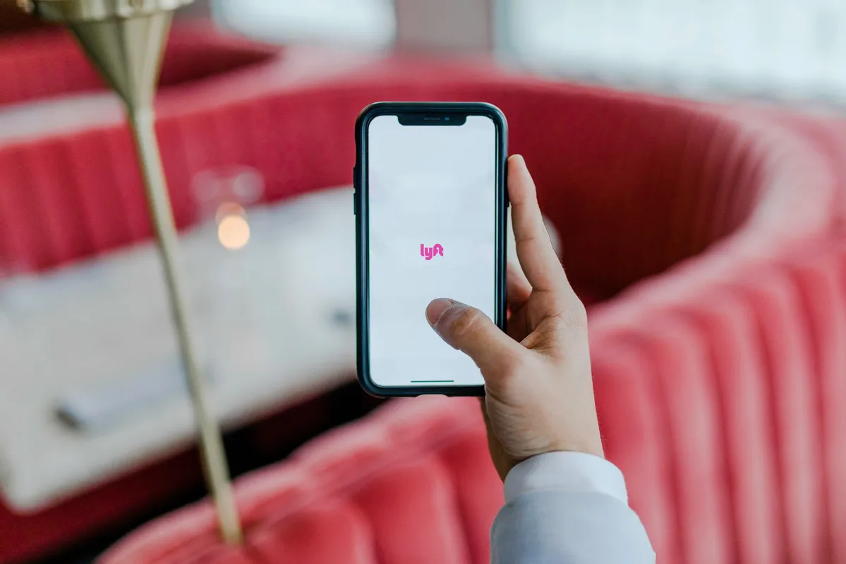 someone holding up a phone with a pink logo on it